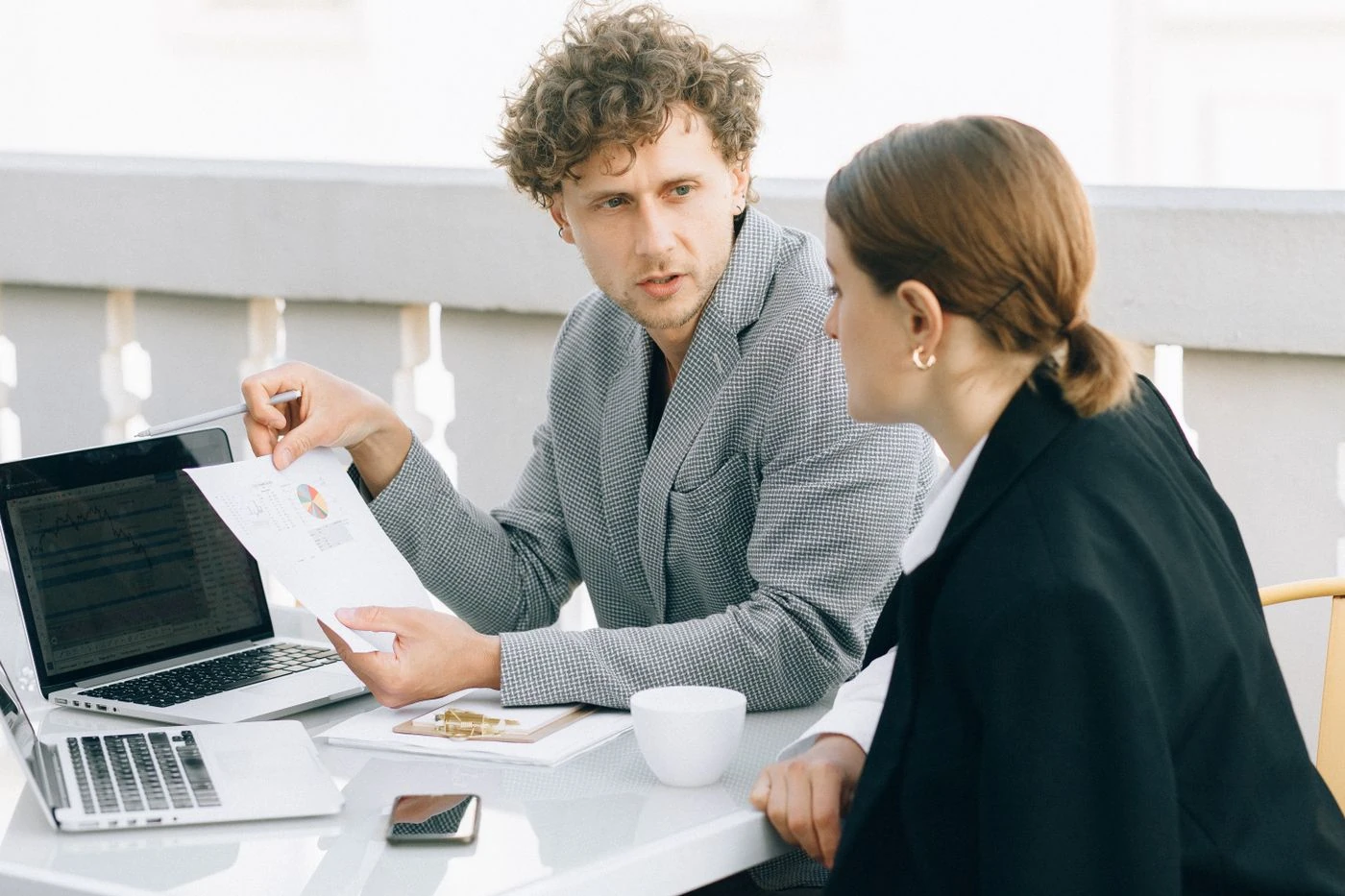 Adviseur en klant bespreken een plan aan tafel