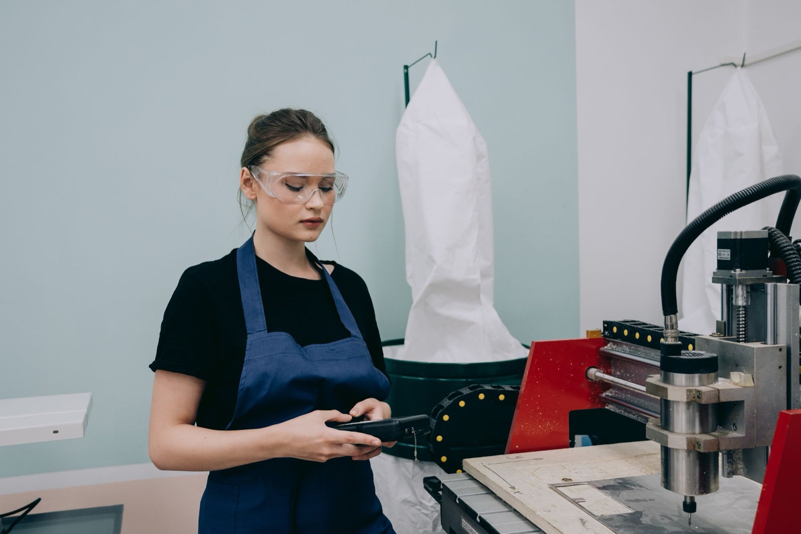 Operator met veiligheidsbril bij een freesmachine in een werkplaats