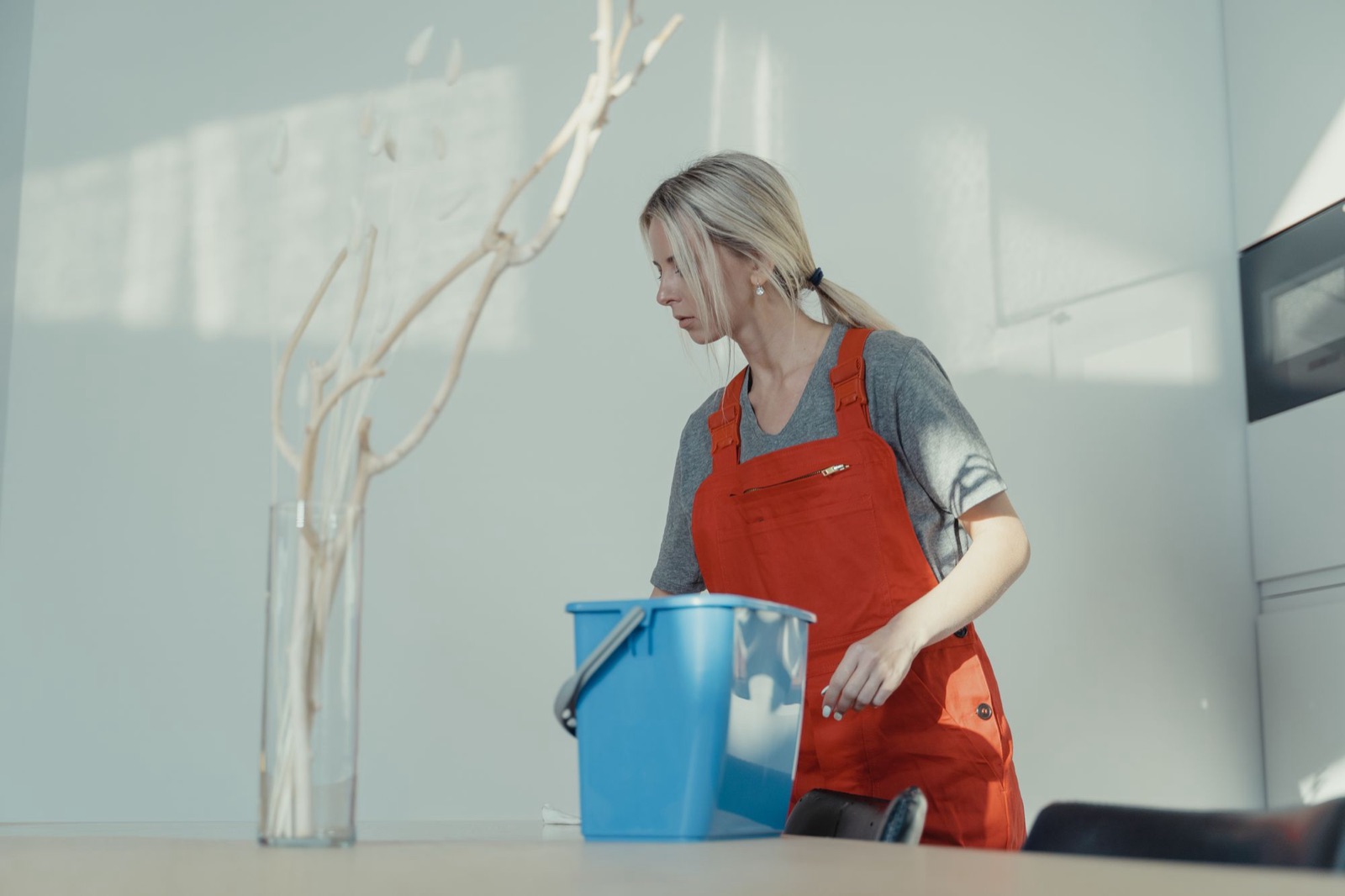 Schoonmaakster aan het werk in een licht kantoor